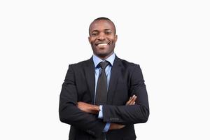 homme d'affaires confiant. joyeux jeune homme africain en tenues de soirée en gardant les bras croisés et souriant à la caméra en se tenant debout sur fond blanc photo