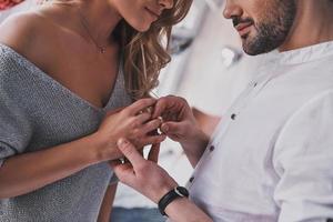 dès maintenant et pour toujours. gros plan d'un jeune homme prenant une bague de fiançailles sur le doigt de sa petite amie alors qu'il se tenait dans la chambre photo