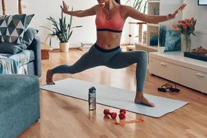 gros plan sur une jeune femme mince en vêtements de sport travaillant tout en passant du temps à la maison photo