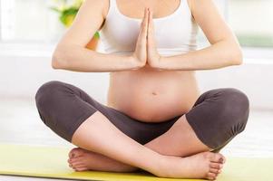 calme et tranquillité. image recadrée d'une femme enceinte faisant la médiation alors qu'elle était assise en position du lotus photo