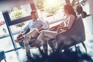 toujours ensemble. beau jeune couple se regardant assis à l'intérieur photo