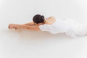 ballerine qui s'étend. vue de dessus de la jeune ballerine faisant des exercices d'étirement photo