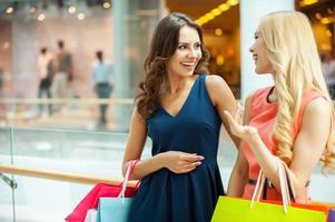 profiter des achats. deux belles jeunes femmes faisant du shopping ensemble et parlant photo