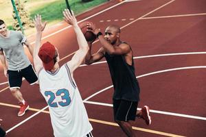 faire ce qu'ils aiment. vue de dessus de jeunes hommes en vêtements de sport jouant au basket tout en passant du temps à l'extérieur photo