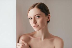 sa confiance transparaît. jolie jeune femme avec des taches de rousseur sur le visage en regardant la caméra et en gardant la main sur l'épaule photo