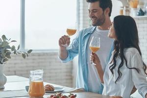 beau jeune couple prenant son petit déjeuner ensemble tout en passant du temps dans la cuisine domestique photo