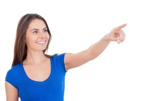 regarde là-bas belle jeune femme souriante pointant vers l'extérieur en se tenant debout isolé sur blanc photo