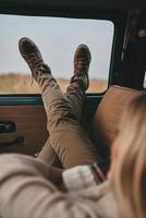 se détendre... gros plan à l'arrière d'une jeune femme se reposant en position allongée sur le siège passager avant dans une voiture de style rétro photo