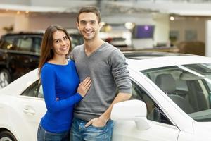 cette voiture est exactement ce que nous voulons. beau jeune couple debout chez le concessionnaire automobile et prenant leur décision photo