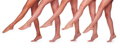 belles jambes. gros plan de cinq belles femmes étirant leurs jambes parfaites tout en se tenant près l'une de l'autre et sur fond blanc photo