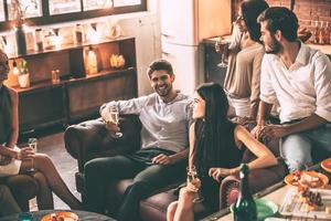 passer du temps avec des amis. vue de dessus de jeunes gens joyeux appréciant la nourriture et les boissons tout en passant du bon temps dans des chaises confortables à la maison ensemble photo