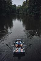 explorer le monde ensemble. vue de dessus d'un beau jeune couple profitant d'un rendez-vous romantique tout en ramant un bateau photo