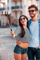 le temps des selfies. joyeux jeune couple d'amoureux faisant selfie sur téléphone intelligent tout en se tenant à l'extérieur photo