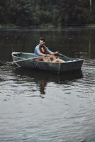 des moments tranquilles ensemble. beau jeune couple embrassant tout en profitant d'un rendez-vous romantique sur le lac photo