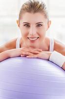 femme avec ballon d'exercice. belle femme mûre se penchant au ballon de fitness et souriant photo