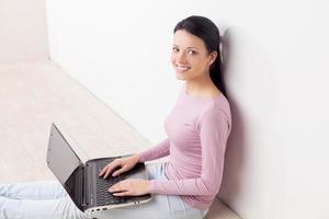 travailler à l'ordinateur. belle jeune femme travaillant à l'ordinateur et regardant la caméra photo