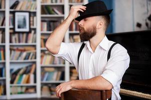 talentueux et créatif. portrait de beaux jeunes hommes barbus assis devant son piano avec les yeux fermés photo