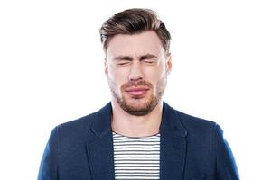 oh non portrait de jeune homme exprimant la négativité et gardant les yeux fermés en se tenant debout sur fond blanc photo