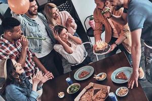 faire un vœu vue de dessus de gens heureux célébrant l'anniversaire entre amis et souriant tout en ayant un dîner photo