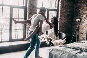 amour pour toujours. jeune couple passionné s'amusant ensemble et ayant l'air heureux tandis que beau jeune homme portant sa petite amie dans les mains photo