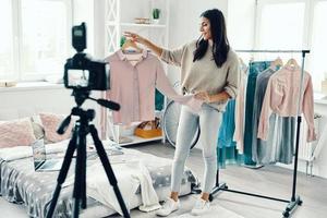 toute la longueur d'une belle jeune femme en vêtements décontractés faisant une vidéo sur les réseaux sociaux tout en passant du temps à la maison photo