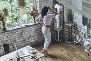 beauté désirable. vue arrière pleine longueur d'une jeune femme attirante regardant dans le miroir à la maison photo