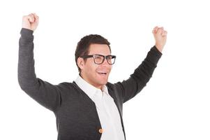 c'est le succès beau jeune homme gardant les bras levés et souriant tout en se tenant isolé sur blanc photo