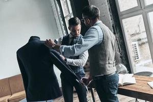 deux jeunes hommes à la mode mesurant des vestes photo