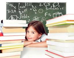 jeune fille mignonne assise à la table et lisant un livre photo