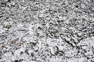 la texture du sol, recouvert d'une fine couche de neige. le sol du jardin en hiver. le sol creusé de près photo