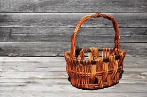 un panier en osier vide de tiges de bois se trouve sur une surface en bois photo