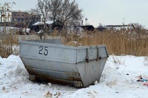 poubelle sur le côté de la rue en hiver avec poubelle à lèvres neige d'hiver. conteneur métallique pour ordures ménagères photo