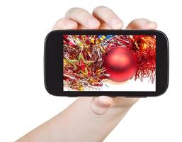 la main tient un smartphone avec des décorations de Noël photo