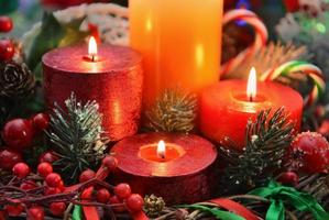 Close up de bougies allumées festives avec conifères et décorations photo