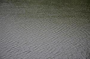 la texture de l'eau de rivière sombre sous l'influence du vent, imprimée en perspective. image horizontale photo