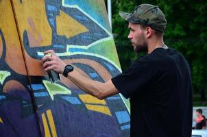 kharkov, ukraine - 27 mai 2017 festival des arts de la rue. de jeunes gars dessinent des graffitis sur des murs en bois portables au centre de la ville. le processus de peinture sur les murs avec des bombes aérosols photo