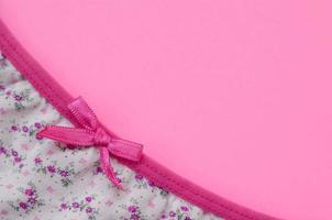 ruban sur sous-vêtements féminins blancs avec dentelle sur fond rose avec espace de copie. concept de blogueur de mode beauté. lingerie romantique pour la tentation de la saint valentin photo