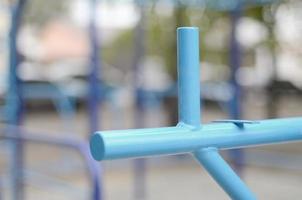 bars sportifs en bleu sur le fond d'un terrain de sport de rue pour l'entraînement en athlétisme. équipement de gym athlétique en plein air. photo macro avec mise au point sélective et arrière-plan extrêmement flou