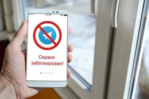 kharkov, ukraine - 27 avril 2018 un téléphone mobile avec l'écran de l'application télégramme avec un panneau d'interdiction et l'accès à l'inscription russe est refusé. roskomnadzor a bloqué le service de télégramme en russie photo