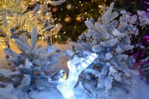 décorations de noël pour le centre commercial. épicéa blanc artificiel. petites aiguilles, décor de guirlande. arbres sur la neige blanche. épicéa décoré de petites boules dorées photo