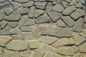 la texture de la route de pierre, de la chaussée, des murs de grandes pierres fortes rondes médiévales grises, des pavés. l'arrière-plan photo