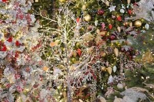 jouets de noël, boules rouges et blanches avec des lumières sur le sapin de noël, branches de sapin photo