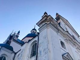 Ancienne église orthodoxe chrétienne pauvre en pierre blanche ancienne avec des croix photo