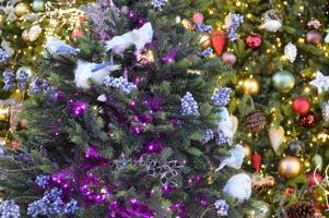 conte de noël. arbre de noël décoré de lumières colorées et de jouets lumineux photo