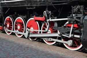 roues de la vieille locomotive à vapeur noire de l'époque soviétique. le côté de la locomotive avec des éléments de la technologie rotative des anciens trains photo