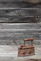 le vieux fer à charbon lourd et rouillé se trouve sur une surface en bois photo