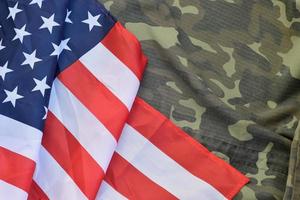 drapeau des états-unis d'amérique et veste d'uniforme militaire pliée. bannière de fond conceptuel de symboles militaires pour les vacances patriotiques américaines photo