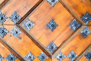 texture de l'ancienne porte épaisse naturelle en bois robuste antique médiévale avec des motifs de rivets et de clous et des serrures en planches de bois. l'arrière-plan photo