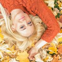 femme allongée sur des feuilles jaunes photo
