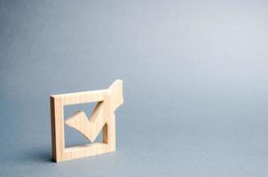 coche en bois pour voter aux élections sur fond gris. élections présidentielles ou parlementaires, un référendum. enquête sur la population, statistiques, tâche. démocratie et liberté. mise au point sélective photo